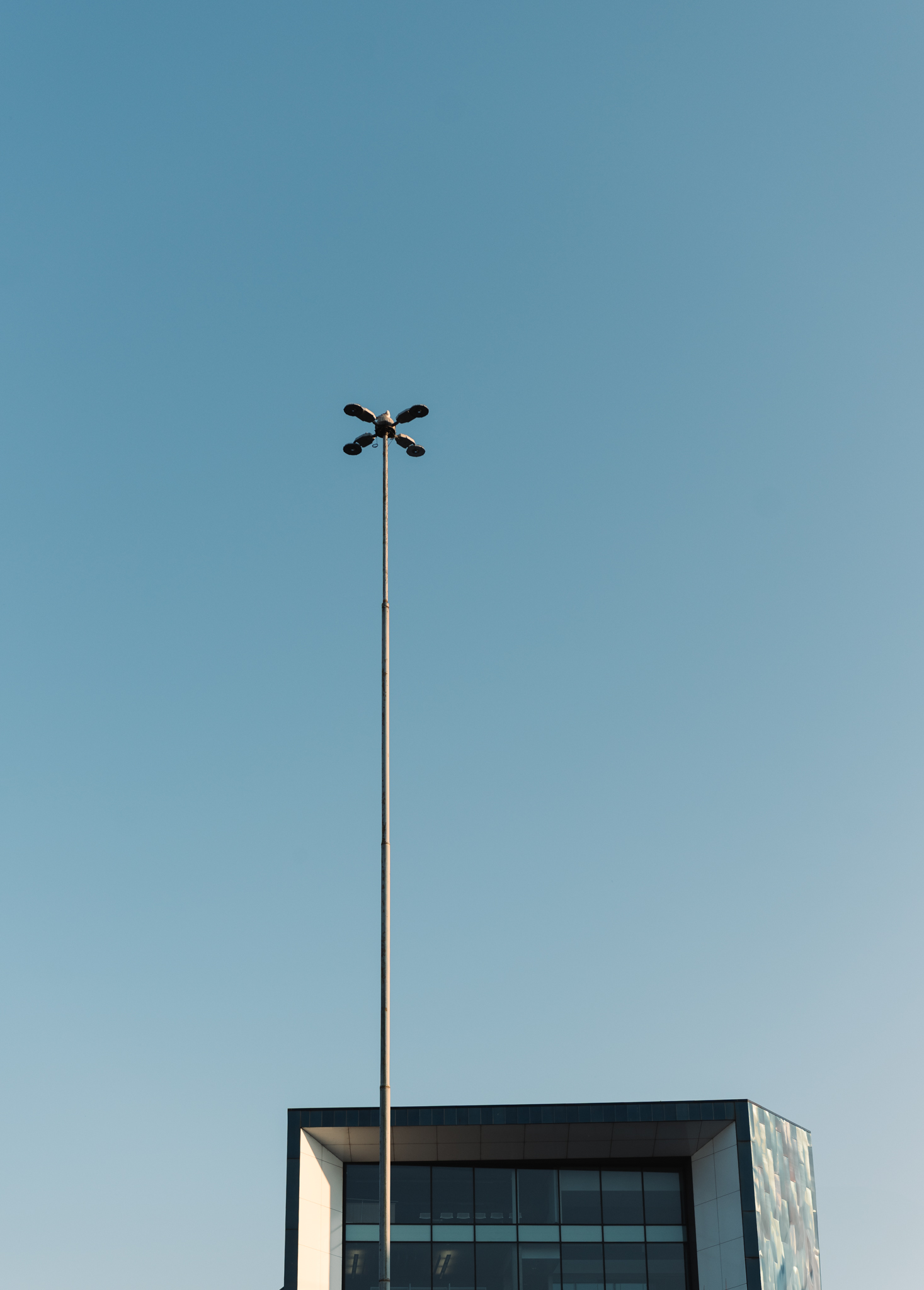 A light pole extending past a square building